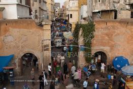 Image du Maroc Professionnelle de  Médina de Casablanca quelque soit l'angle choisi , des amas de caisses, d'objets ou de poubelles empestent ce lieu malgré qu'il fait partie du patrimoine historique de la Médina de Casablanca. El Bab E Jdid subit une dégradation due au vieillissement et à l’absence d’entretien, mais surtout au voisinage qui ne respect rien pour se protéger du soleil une bâche a été accroché à gauche avec du ciment sur la muraille de la ville au Boulevard Tahar El Aloui, ex (2e Tirailleurs). Par ailleurs les deux petites portes réservées aux passage des piétons sont devenue la propriété des cafés qui se situent de chaque côté de la porte dont on aperçoit quelques chaises, Vendredi 10 juillet 2009. (Photo / Abdeljalil Bounhar) 